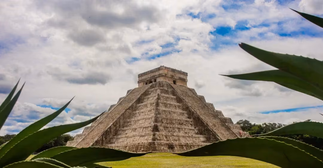 The pyramid of Chichen Itza under a blue sky
