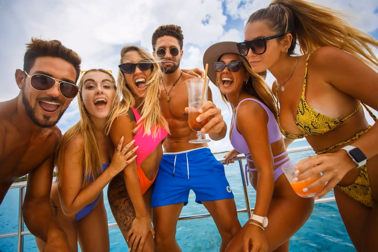 Group of friends celebrating with drinks on a boat cruise in Tulum