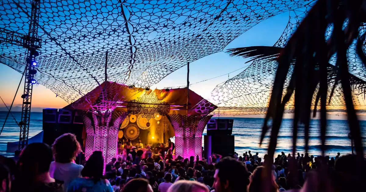 A crowd in front of the lit stage at Papaya Playa Project at night