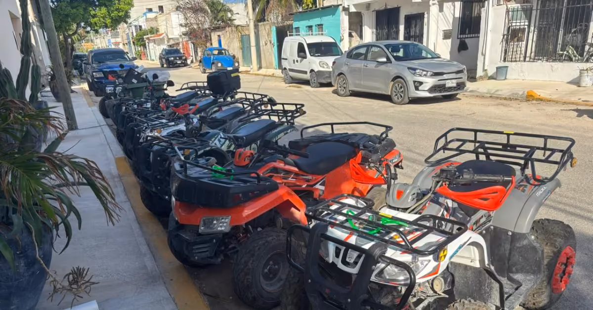 ATVs in red, black, and white are parked on a residential street with cars and houses visible in the background.