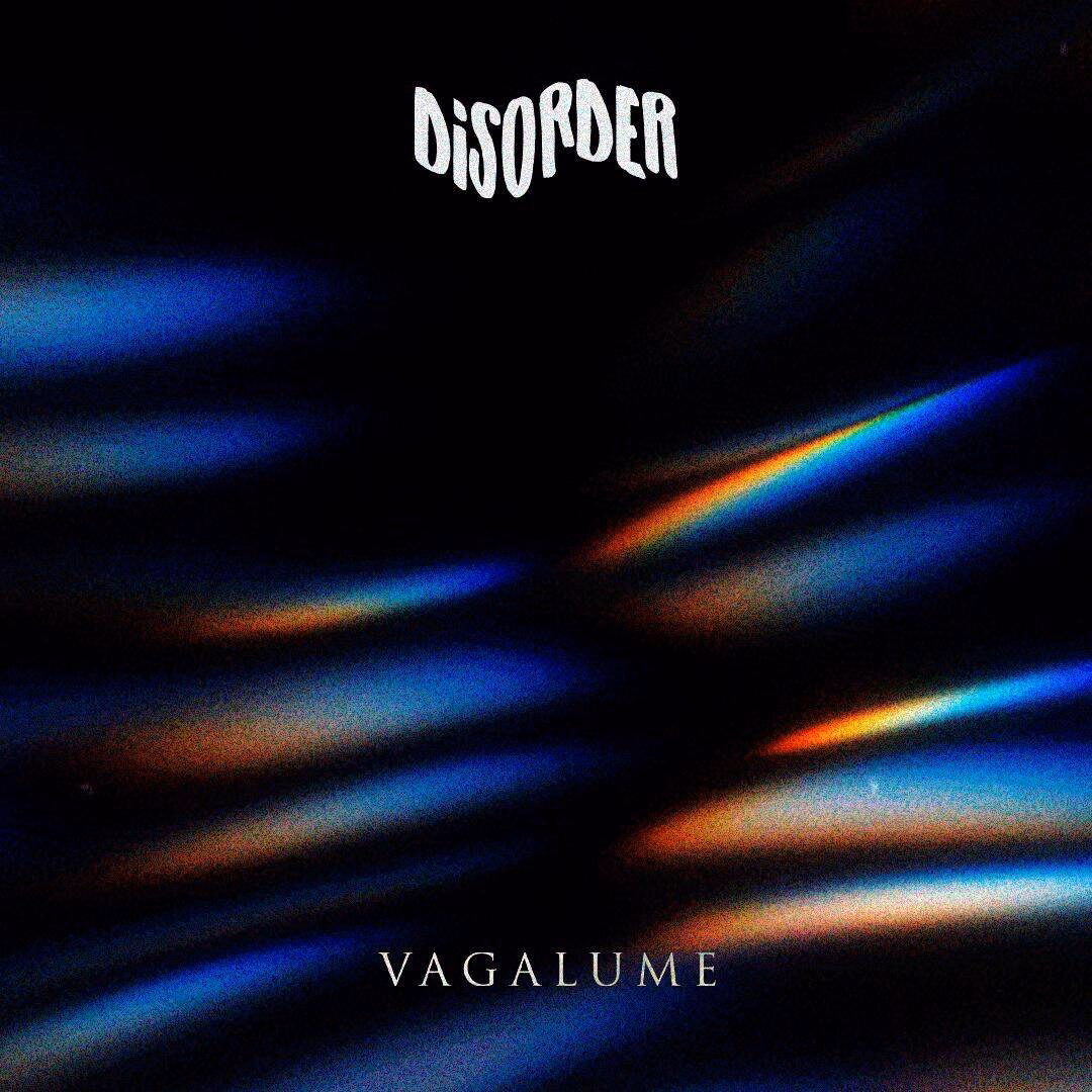 Abstract image with wavy, iridescent blue and rainbow light patterns on a dark background. The word DISORDER appears at the top in white, distorted letters, with Vagalume Tulum in smaller white text at the bottom.