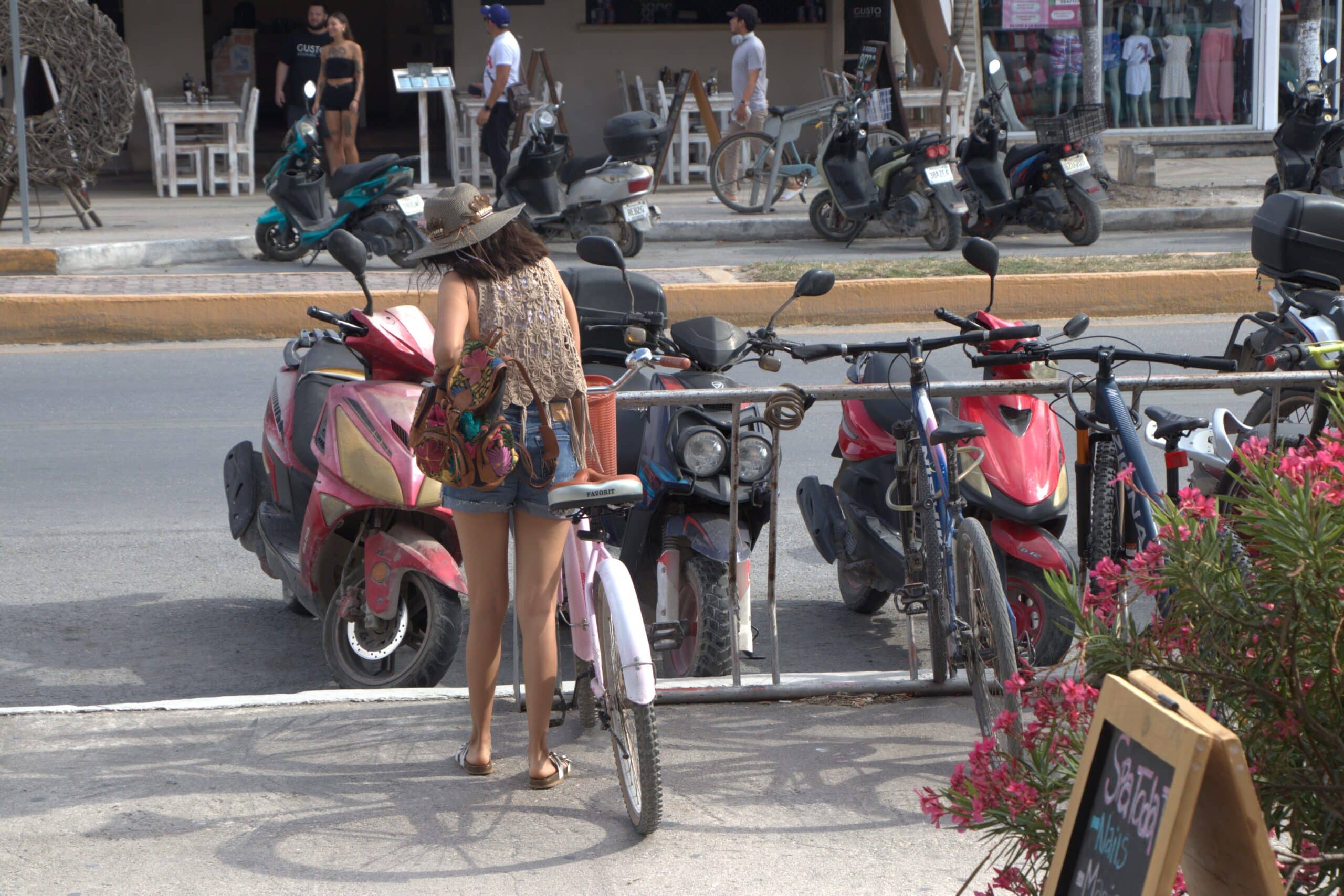 A woman parking her bike on the main road in Tulum Pueblo