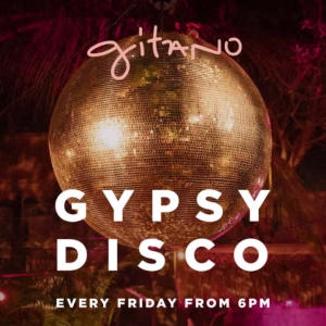 A golden disco ball under pink lights with